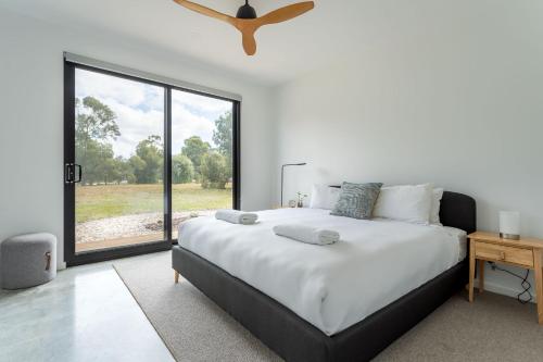 a bedroom with a large bed and a large window at The Tempest I Private Properties in Quindalup