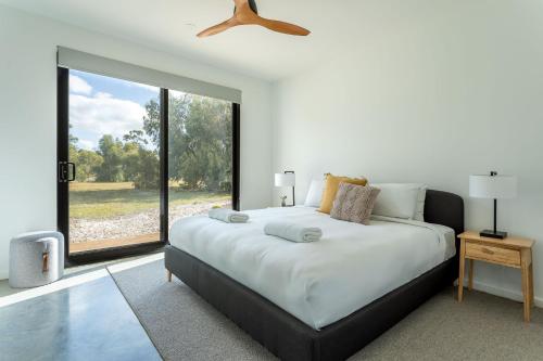 a bedroom with a large bed and a large window at The Tempest I Private Properties in Quindalup