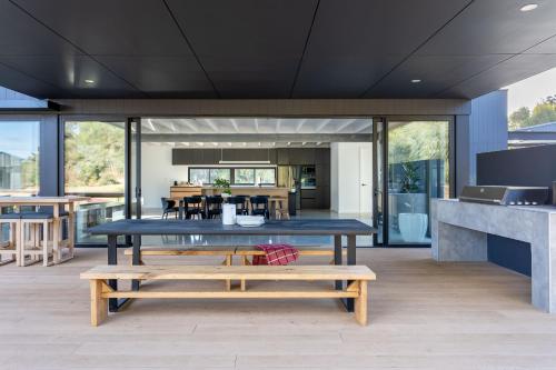 a dining room with a table and benches at The Tempest I Private Properties in Quindalup