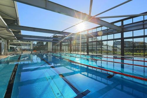 une grande piscine bien exposée à travers les fenêtres dans l'établissement Parc Montfleury, à Cannes