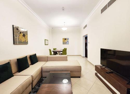 a living room with a couch and a tv at RH - Spacious & bright 01BR, Near mall of Emirates in Dubai