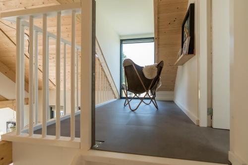 a room with a chair next to a staircase at Riethoek Westerschouwen in Burgh Haamstede