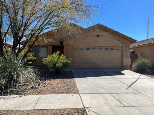 a house with a garage and a driveway at Lady T’s Serenity Getaway near TUS airport in Tucson