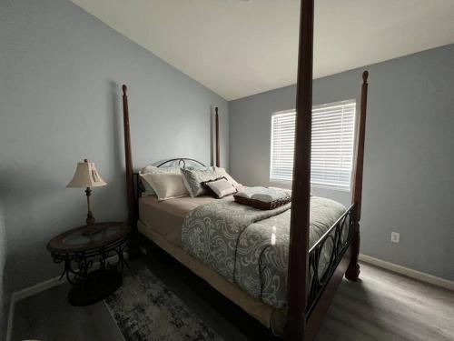 ein Schlafzimmer mit einem Bett und einer Lampe und einem Fenster in der Unterkunft Lady T’s Serenity Getaway near TUS airport in Tucson