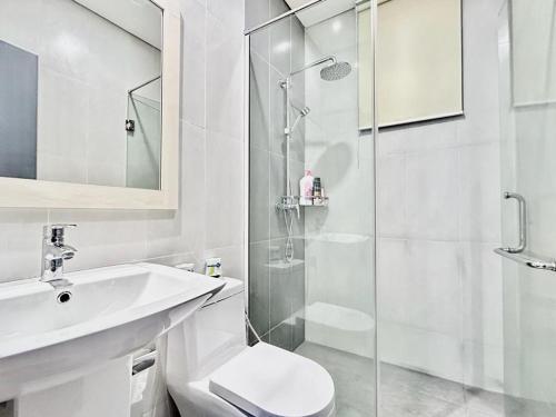 La salle de bains est pourvue de toilettes, d'un lavabo et d'une douche. dans l'établissement Jeff & Ricky Homestay 87@ Trinity Residence, à Kuching