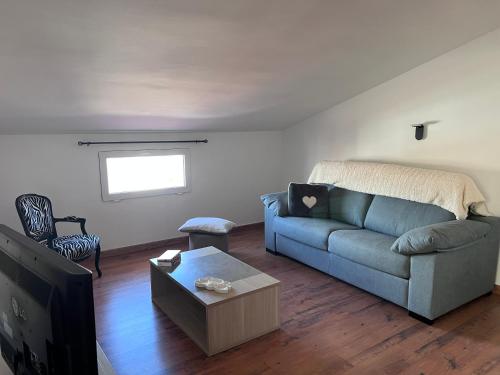 ein Wohnzimmer mit einem blauen Sofa und einem TV in der Unterkunft L’Amirall in Roses