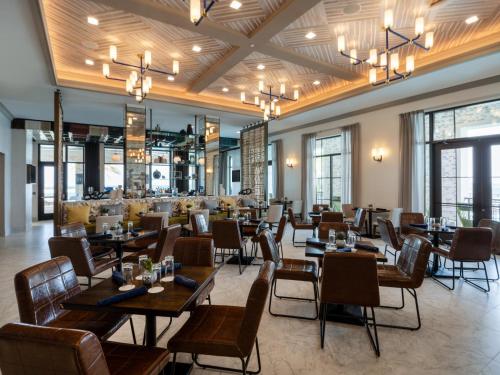 a restaurant with tables and chairs and windows at Hotel Indigo - Panama City Marina by IHG in Panama City