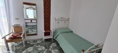 a bedroom with a bed and a chair and a mirror at I Sollazzi in Palermo