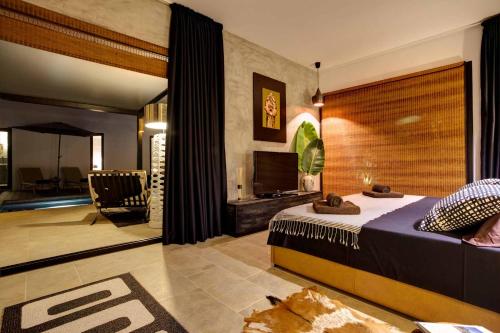 a bedroom with a bed and a living room at Villa Ha Taew in Sant Josep de sa Talaia