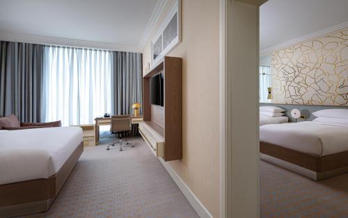 a hotel room with two beds and a desk at Baku Marriott Hotel Boulevard in Baku