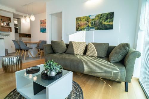 een woonkamer met een bank en een tafel bij Apartment Wing 77 by Belmont Realty in Zadar