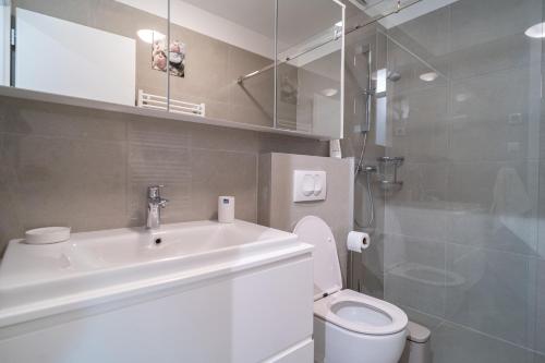 een badkamer met een wastafel, een toilet en een douche bij Apartment Wing 77 by Belmont Realty in Zadar