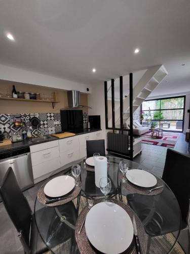 une cuisine avec deux tables et des chaises dans l'établissement Le Patio - Appartement calme - Hyper centre Pau, à Pau