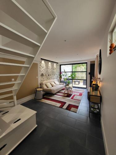 un salon avec un escalier et un canapé dans l'établissement Le Patio - Appartement calme - Hyper centre Pau, à Pau
