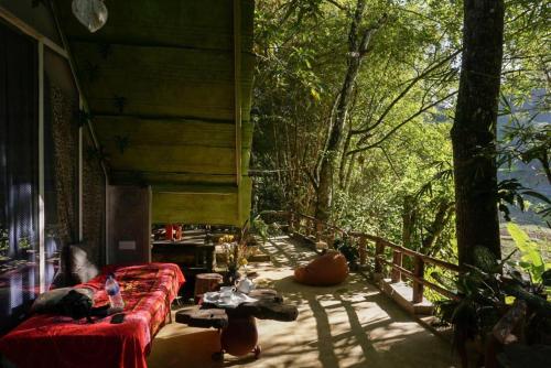 a living room with a red couch in a forest at Moksha eco villa Ella in Ella