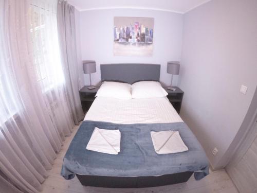 ein kleines Schlafzimmer mit einem Bett und zwei Lampen in der Unterkunft Apartament Kłos in Wisła