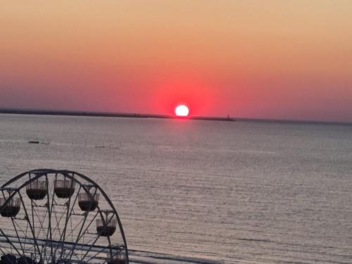a ferris wheel with the sunset in the background at Garsoniera Panoramic in Năvodari