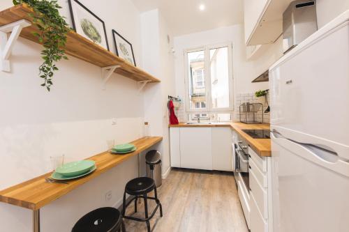 - une cuisine avec des appareils blancs et un comptoir en bois dans l'établissement Loft Latin, à Paris