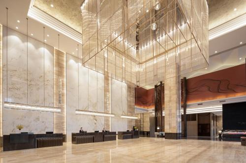 a lobby of a hotel with a large chandelier at Wanda Jin Jiamusi in Jiamusi