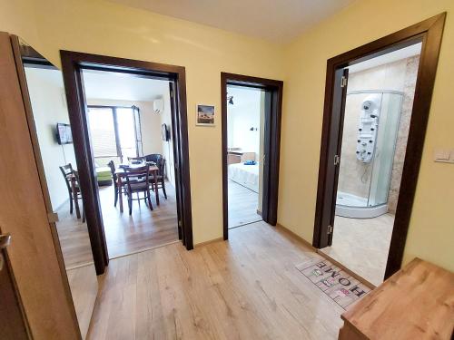 a room with doors and a dining room with a table at Апартаменти за гости Делукс in Burgas City