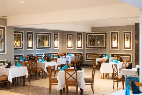 a dining room with white tables and chairs at Oz Hotels Incekum Beach in Alanya
