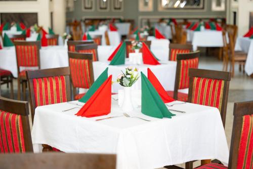 a group of tables with red and green napkins at Oz Hotels Incekum Beach in Alanya