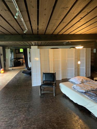 Zimmer mit einem Bett und einem schwarzen Stuhl in der Unterkunft Auszeit auf dem KulturGut Hirtscheid in Hirtscheid