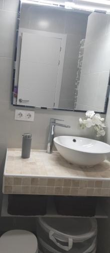 a bathroom with a sink and a toilet and a mirror at Sobre el Mar en Edificio Magallanes in El Médano
