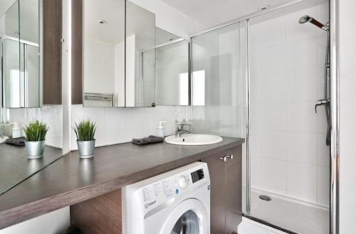 a washing machine in a bathroom with a sink at Appartement Quartier Republique in Paris