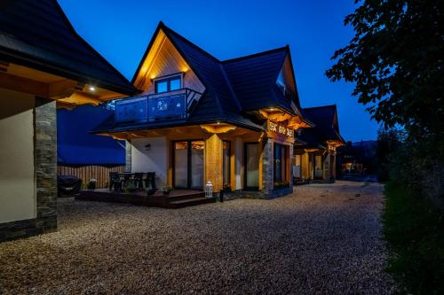 a house with a black roof at night at Osada Zbójnicka Turnia in Kościelisko