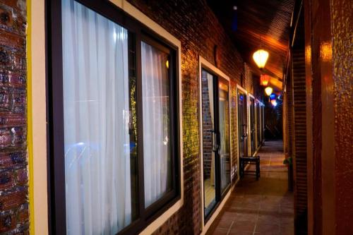an alley with windows on a brick building at D&D riverside Homestay in Xuân Sơn