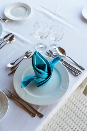 a white plate with a blue ribbon on a table at Oz Hotels Incekum Beach in Alanya