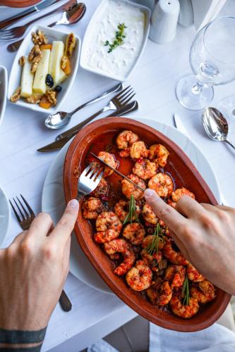 a person holding a plate of shrimp on a table at Oz Hotels Incekum Beach in Alanya