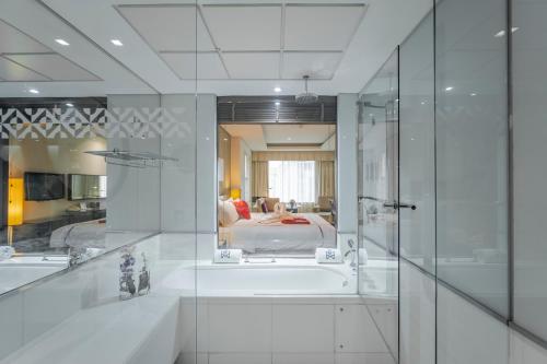 a bathroom with a bath tub and a bedroom at Majestic Premier Hotel Burdubai in Dubai