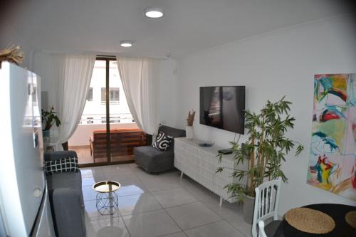 - un salon avec un canapé et une télévision dans l'établissement Sobre el Mar en Edificio Magallanes, à El Médano