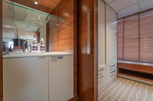 a kitchen with white cabinets and a counter top at Majestic Premier Hotel Burdubai in Dubai