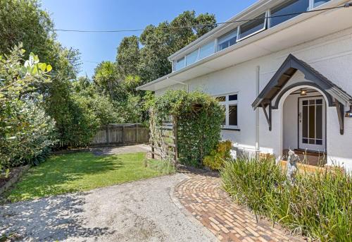 una casa blanca con un camino que conduce a un patio en Stunning, 4 Bedroom Villa Conversion, en Auckland