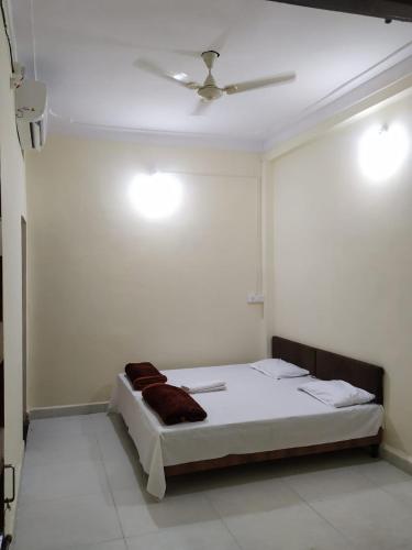 a bed in a room with a ceiling fan at Parshuram Darshan Guest House in Ujjain