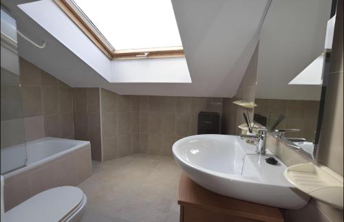 a bathroom with a sink and a toilet and a skylight at Apartamento Mar de Ardora Finisterre in Finisterre