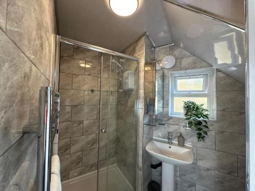 a bathroom with a shower and a sink at THE GLASS HOUGHTON APARTMENTS in Castleford