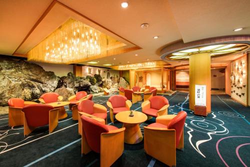 a restaurant with orange chairs and tables in a room at Maruei in Fujikawaguchiko