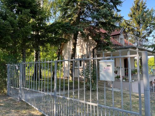 a fence in front of a house with a tree at Vila Vera Novosadska 15 in Velika Remeta