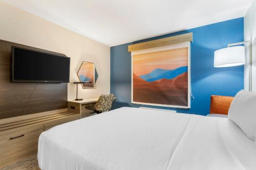 a hotel room with a bed and a flat screen tv at Holiday Inn Express Belgrade-Bozeman Area by IHG in Belgrade