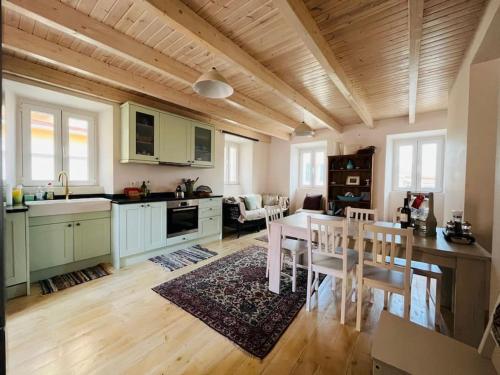 cocina y sala de estar con mesa y comedor en Traditional Detached Corfu House, 50m to village square en Liapades
