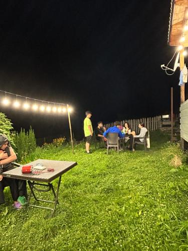 a group of people sitting in a yard at night at MTASHI - მთაში in Ushguli