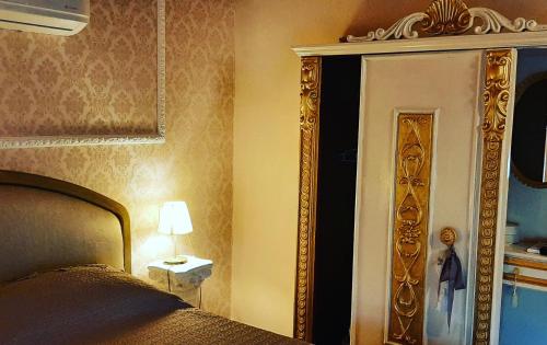 1 dormitorio con cama, espejo y lámpara en Antica Norma Alloggio Turistico, en Norma