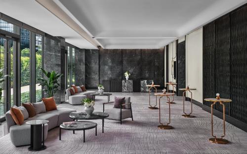 a living room with a couch and tables at InterContinental Shenzhen WECC by IHG in Shenzhen