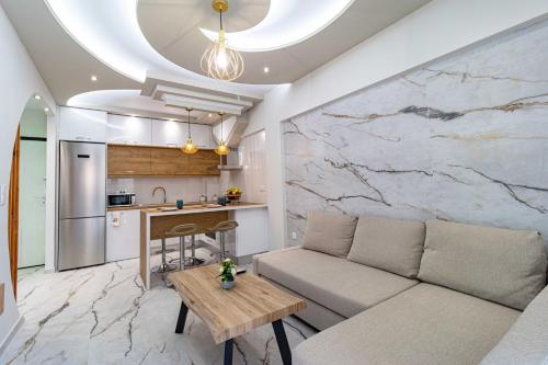 a living room with a couch and a kitchen at Sergio Luxury Appartment in Nea Potidaea