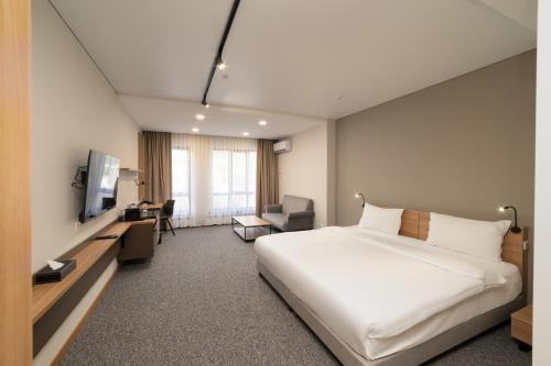 a hotel room with a bed and a television at Ambassador Hotel in Bishkek
