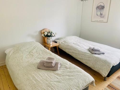 two beds in a room with towels on them at Ruim en licht familiehuis No 21 in Föllinge